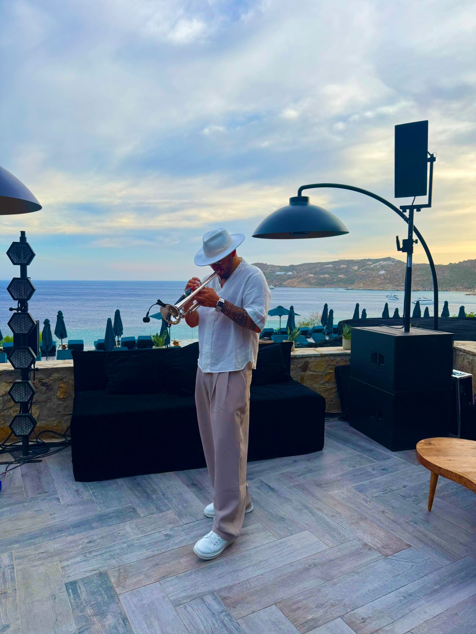 Sunset trumpet performance on a beach club terrace in Mykonos