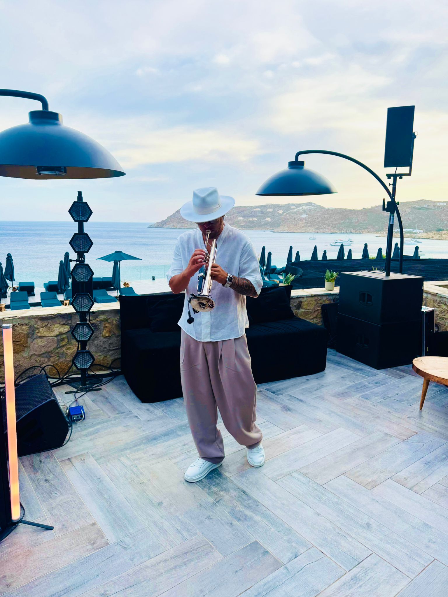 Golden hour trumpet performance by the sea in Mykonos